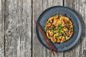 Japanese pancake with cabbage on a plate, top view