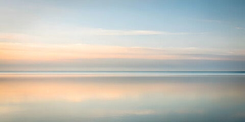 Naklejka premium Tranquil Horizon: A serene seascape at dawn, captured with a soft focus, evokes tranquility and a sense of peace. The gentle, pastel hues of the sky and water create a calming ambiance. 