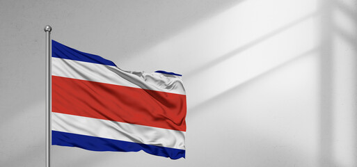 Fototapeta premium Costa Rica national flag cloth fabric waving on beautiful window light grey Background.