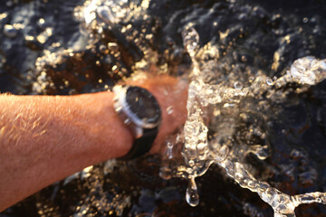 Swimming Watch. Smartwatch for swimming training. Watersport with sports watch. Multi-sport with smartwatch. Watch for Watersports. Waterproof Watch on hand of the swimmer. Swim Smartwatch underwater.