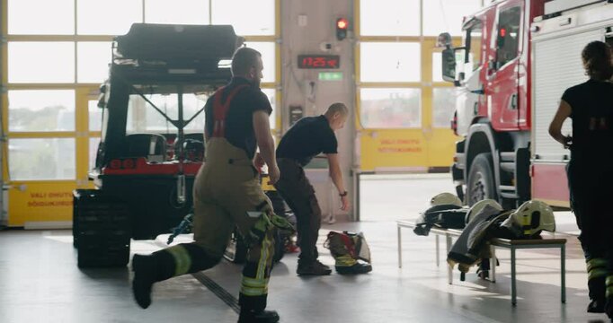 Diverse Firefighter Team with a Female Among Them, Rushes to the Garage When the Alarm Rings. Male Comes Down on a Pole. They Gear Up and Board the Fire Truck, Speeding Away to Respond to the Call