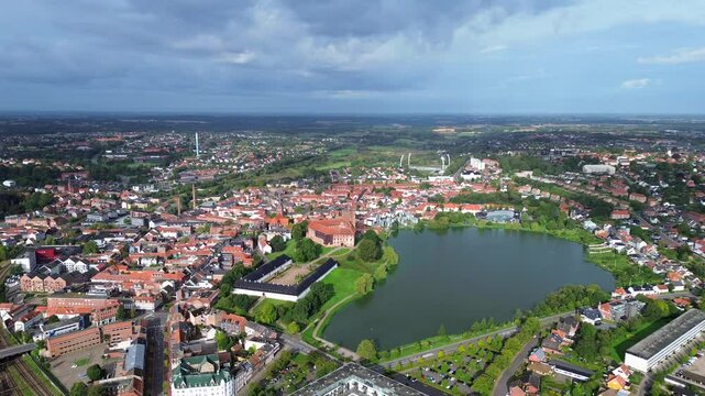 Aerial drone 4K film of Danish city of Kolding with and historic city with keep or castle near city center and lake