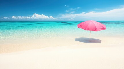 Fototapeta premium A pink umbrella is set up on a serene sandy beach, surrounded by clear turquoise waters and a bright blue sky dotted with clouds