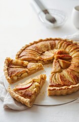 Vegan simple apple pie on a white table in a white plate. Linen napkin and a spoon in a frame. Neutral photo with daily light.