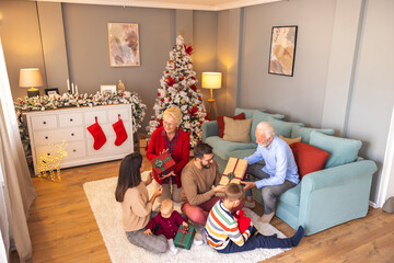Family exchanging Christmas presents at home