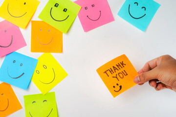 Thank you and smile icon inspirational handwriting on sticky notes on hand held