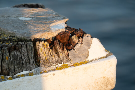 Fischerei - alter, abgesplitterter Holzpoller in wei&szlig;er Farbe gestrichen