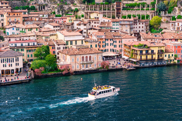 Boat with passengers sailing to Limone sul Garda on Lake Garda. Tourist and leisure transport on...