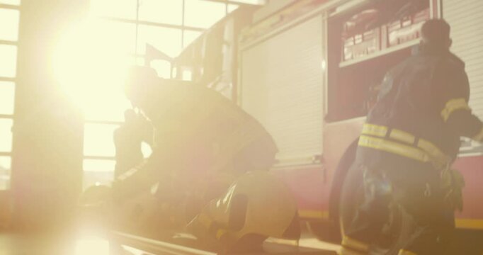 Crew of Firefighters Running to Gear up and Board a Fire Truck Together. Team of Firefighters in the Fire Station Demonstrating Urgency and Readiness for an Emergency Call. Handheld Footage