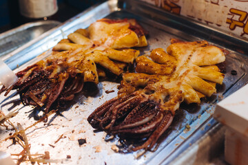 Korean Spicy Grilled Squid, Ojingeo tonggui, grilled octopus tentacles, variety of different street food selection in Seoul, South Korea, night market with local vendor stalls cooking tasty dishes