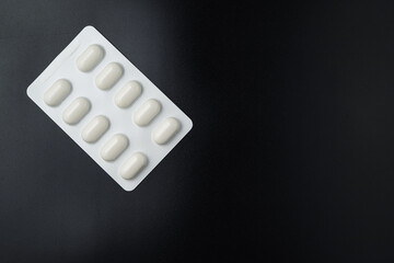 Tablet pills blister Medicine capsules on a black background