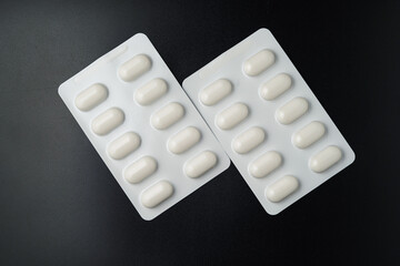 Tablet pills blister Medicine capsules on a black background