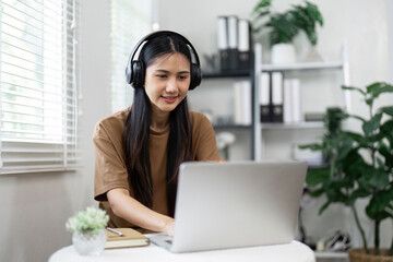 Young Woman Using Laptop with Headphones in Modern Home Office, Embracing Technology Lifestyle for Work and Leisure