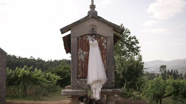 lace wedding dress elegantly Hung on Rustic Espigueiro in Minho, Northern Portugal