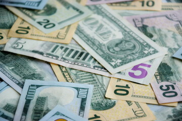 Big amount of US dollar bills in different nominations on table. Many dollar banknotes under...