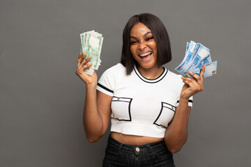 A happy young nigerian woman showing some new naira notes.