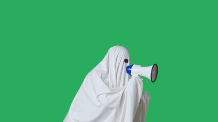 Funny halloween ghost in white sheet talks advertises in loud speaker, isolated on chroma key green screen background. Happy halloween spooky concept.