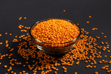 Red lentils in glass bowl. Dry orange lentil grains, heap of dal, raw daal, dhal, masoor