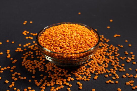 Red lentils in glass bowl. Dry orange lentil grains, heap of dal, raw daal, dhal, masoor