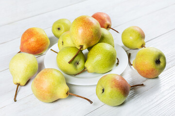 Fresh pears on plate on wooden background. Selective focus