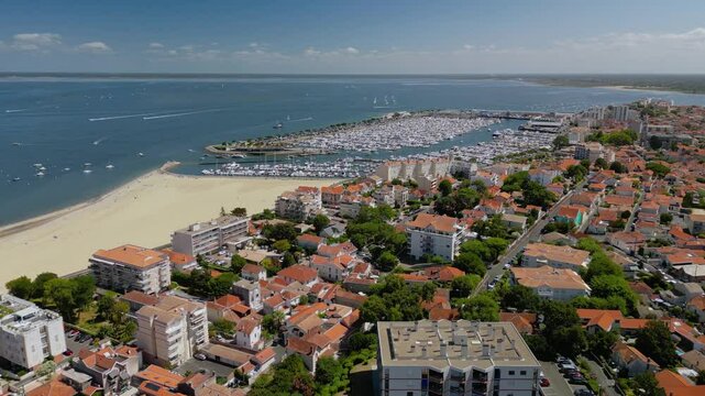 The drone aerial footage of yacht marina ad the beach of Arcachon, France. Arcachon is a commune in the southwestern French department of Gironde. It is a popular seaside resort on the Atlantic coast.