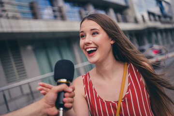 Photo of lovely cheerful popular girl giving interview answering to journalist speaking in...