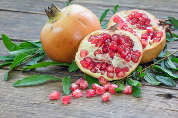 pomegranate and raw pomegranates on a wooden background