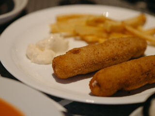 A plate with fired meat, potatoes, and sauce