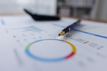 Business analyzing financial charts at desk, calculator and a pen to review data and make important business decisions
