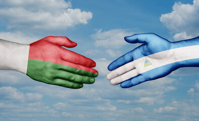 Nicaragua and Madagascar country handshaking with flags, consensus concept international co-operation illustration