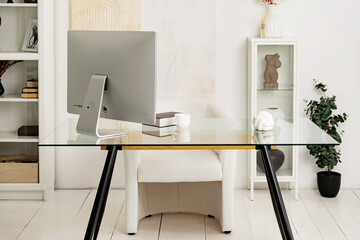cozy home office in a modern studio apartment with a desk, computer, books, decor, flowers in flower pots