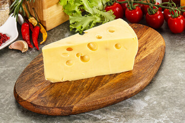 Swiss Maasdam cheese triangle over board