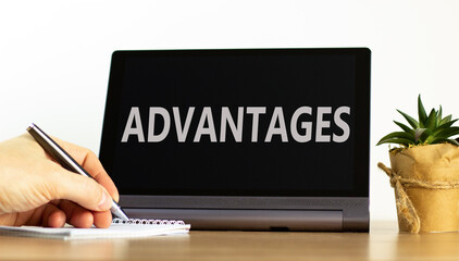 Advantages symbol. Concept word Advantages on beautiful black tablet. Beautiful wooden table white background. Businessman hand with pen. Business advantages concept. Copy space.