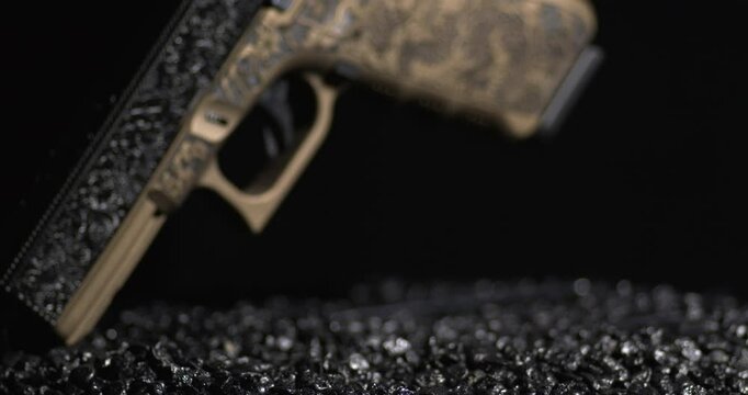 Etched Metal Version Pistol Pointed Down On Gunpowder Granules. closeup, rotating shot