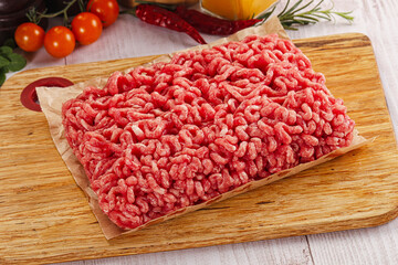 Raw minced beef meat over board