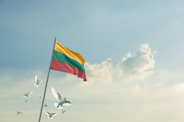 Lithuania flag waving with flying doves in beautiful sky. Lithuania flag for Republic Day and Independence Day.