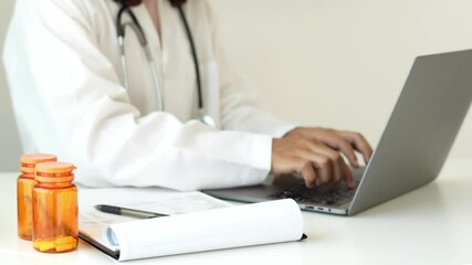 The female doctor sat and checked the patient's history and used a laptop to record patient information at the hospital. Medical concepts and interests.
