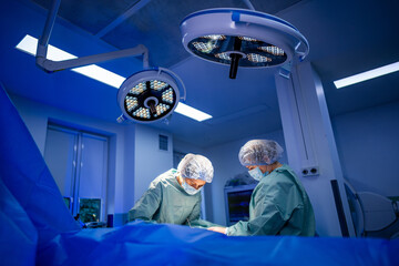 Surgeons at work under bright lights.