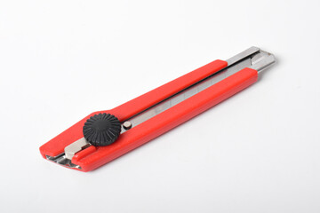 Red utility knife cutter isolated on white background. Stationery cutter knife