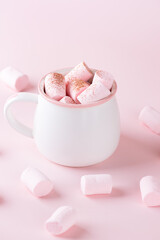 Cup of hot cocoa drink with marshmallows on pink background. Vegan, sugar and lactose free. Vertical orientation.
