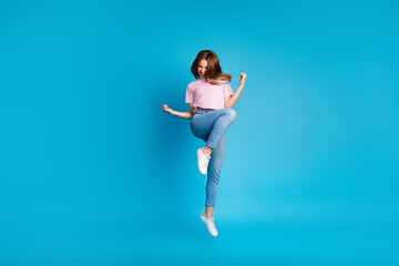 Full size photo of pretty young girl winning raise fists jumping wear trendy pink striped outfit...