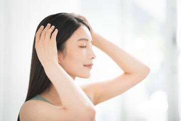 A woman massaging her head with both hands.