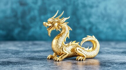 Fototapeta premium Golden dragon statue on a textured blue background, showcasing exquisite craftsmanship and intricate details.