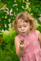 Child holding a snail on his hand. Selective focus.