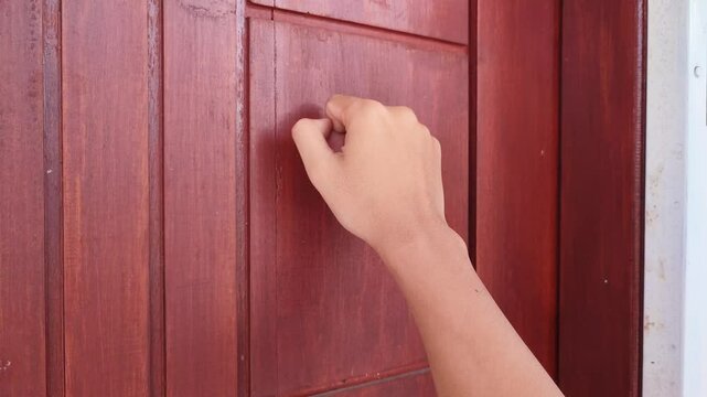 Knocking on the wooden door of the house