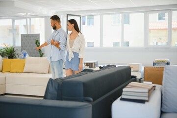 Obraz premium Married couple chooses the best new sofa in a furniture store