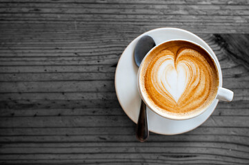 cup of coffee cappuccino latte art on wooden table - heart pattern