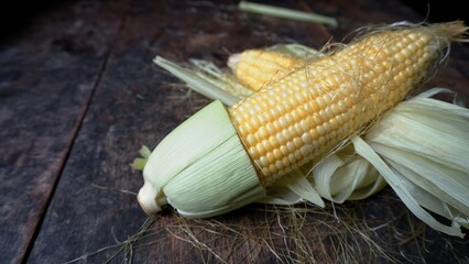 Tasty sweet corn cobs on wooden table. Space for text. top view