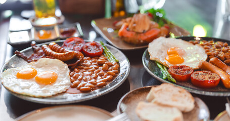 English breakfast menu fried eggs baked beans in tomato sauce and bacon sausage in plate