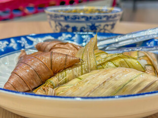 Close-up of traditional malaysia food arranged on beautifully decorated blue and white plate, highlighting the intricate folds and textures.